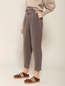 Calça em alfaiataria com detalhe no cós, pregas, bolsos faca e fenda na barra Biamar