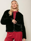 Casaco em pele fake com gola redonda, fechamento em zíper e mangas de cava posta Biamar