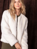 Casaco em pele fake com gola redonda, fechamento em zíper e mangas de cava posta Biamar