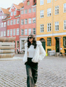 Casaco em pele fake com capuz, fechamento frontal em botões e mangas de cava posta Biamar