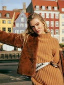 Casaco em pele fake com gola redonda, fechamento em zíper e mangas de cava posta Biamar