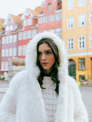 Casaco em pele fake com capuz, fechamento frontal em botões e mangas de cava posta Biamar